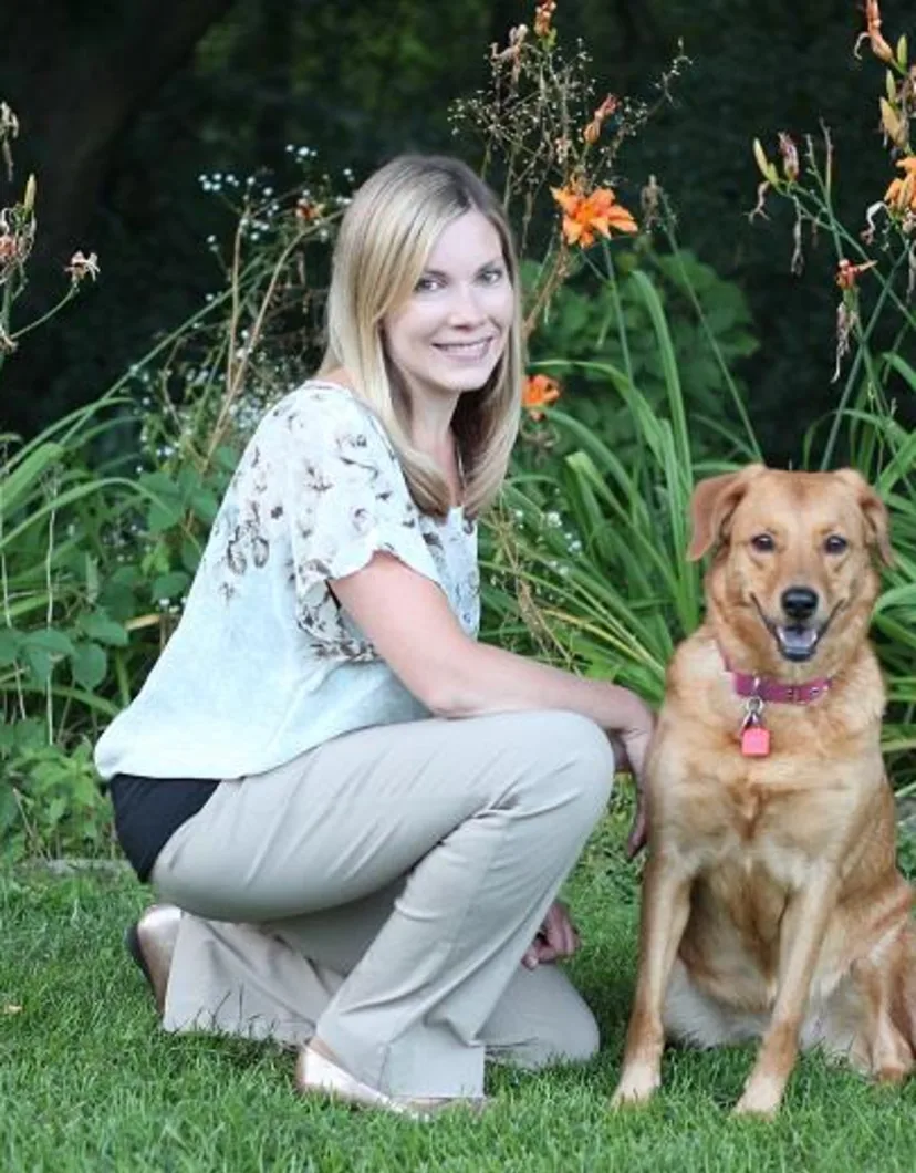  Dr. Kristine Kistner's staff photo from North Lake Veterinary Clinic and her golden retriever next to her posing outside on a lawn